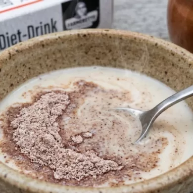 Mixing ragi milk powder into warm milk for a healthy diet.